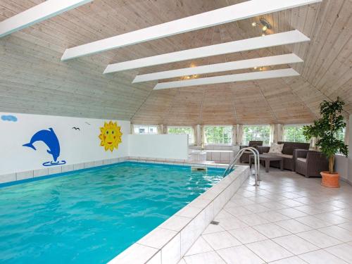 a swimming pool in a building with a large swimming pool at 5 star holiday home in Væggerløse in Bøtø By
