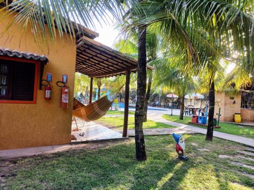 a toy shark standing next to a palm tree at Hotel Enseada Maracajaú in Maracajaú