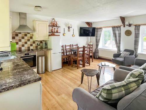 eine Küche und ein Wohnzimmer mit einer Couch und einem Tisch in der Unterkunft Mill Cottage - Ukc3374 in West Down
