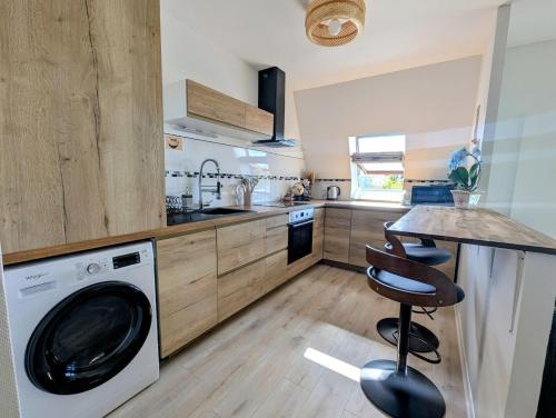 a kitchen with a washing machine and a table at Appartement ZEN - 5 minutes du centre, parking gratuit in Nancy