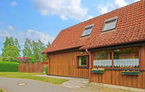 a house with a red roof with flowers in windows at Ferienwohnung Zislow in Zislow