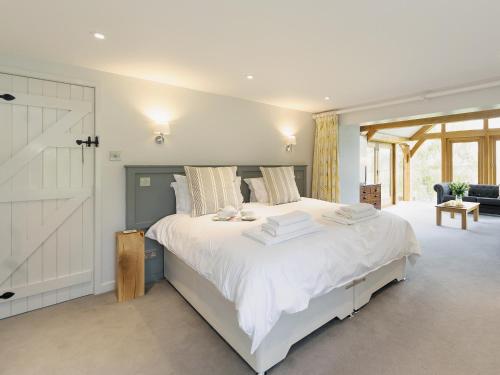 a white bedroom with a large bed with white sheets at The Row in Much Marcle
