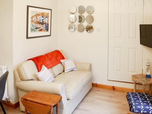 a living room with a white couch and a table at The Honeypot in Padstow