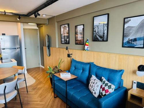 ein Wohnzimmer mit einem blauen Sofa und einem Tisch in der Unterkunft SaampaStudio in São Paulo