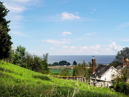 a house on a hill with the ocean in the background at Seashells in Dunster