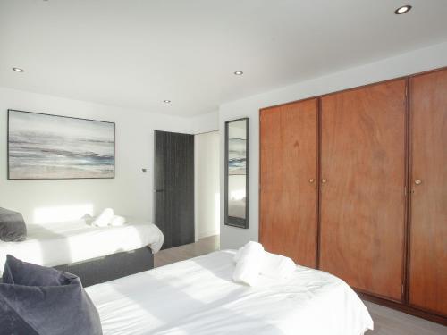 a bedroom with two beds and a wooden cabinet at Dehra Dun in Torpoint