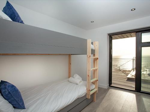 a bedroom with a bunk bed and a ladder at Dehra Dun in Torpoint