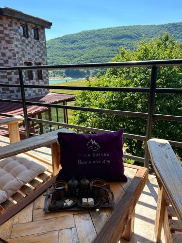 a pair of glasses sitting on a wooden bench on a balcony at Vila Simona in Mavrovo