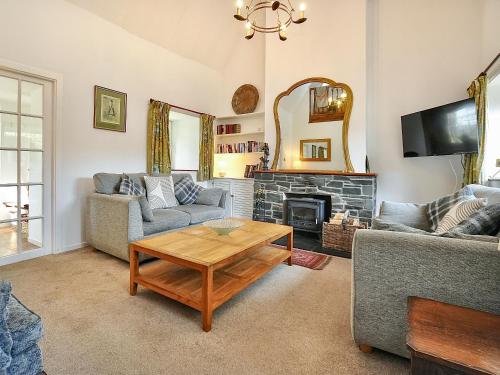 un soggiorno con due divani e un tavolo di Holly Cottage - 28140 a Boreland of Colvend