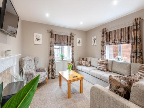 a living room with a couch and a table at Cherry Blossom - Uk48837 in Skegness