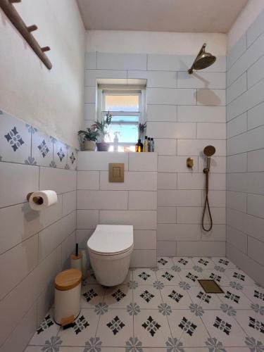 a white bathroom with a toilet and a window at טרקוטה in Odem