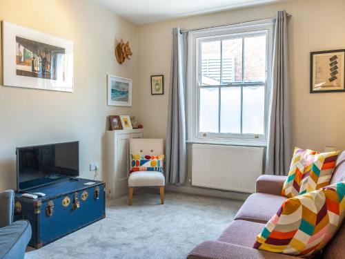 a living room with a couch and a tv at Mcenroe Cottage in Broadstairs