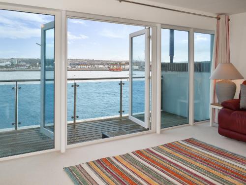 Una sala de estar con vista al agua. en Kings Haven, en Turnchapel