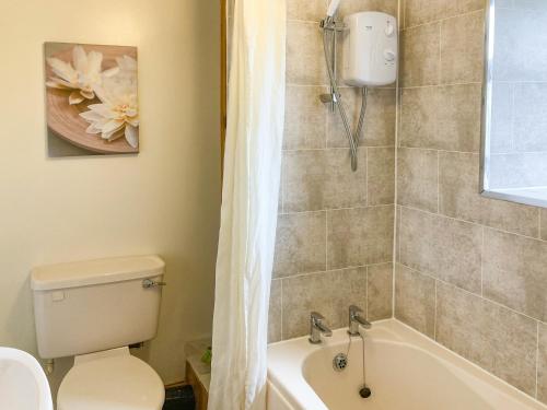 a bathroom with a tub and a toilet and a shower at The Milking Parlour in Alston