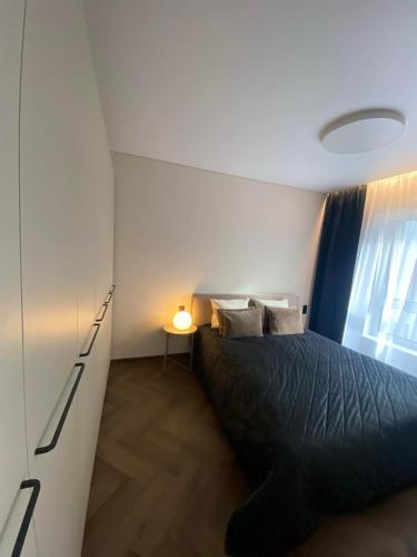 a bedroom with a black bed and a window at Two bedroom LUXURIOUS Spacios Apartment in Vilnius