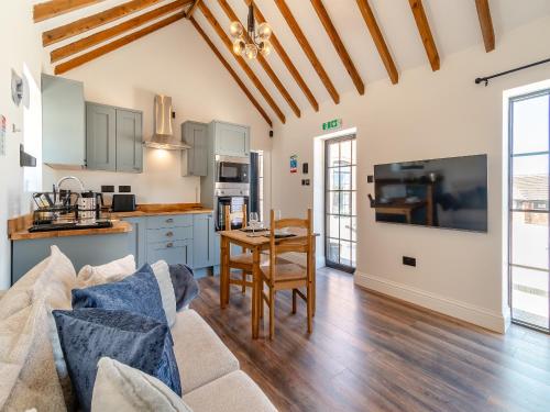 a kitchen and living room with a couch and a table at Fountain Front Barn - Uk45937 in Corley