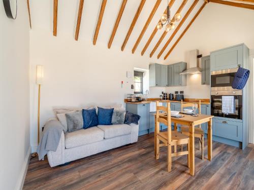 a living room with a couch and a table at Fountain Front Barn - Uk45937 in Corley