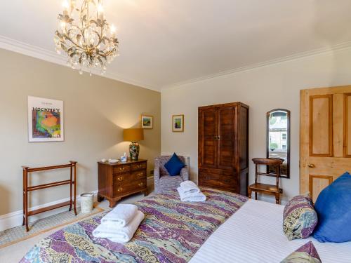 a bedroom with a large bed and a chandelier at Temple House in West Burton