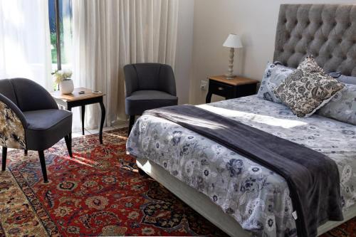 a bedroom with a bed and a chair and a window at Sheilan House in Port Alfred