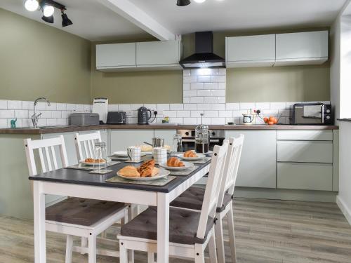 a kitchen with a table with food on it at The Old Post House in Walton