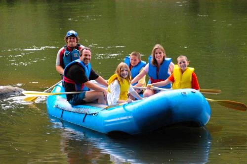 a group of people on a raft in the water at Riverfront Cabin Rental with a Private Beach on Youghiogheny River near Pittsburgh, Pennsylvania in Confluence