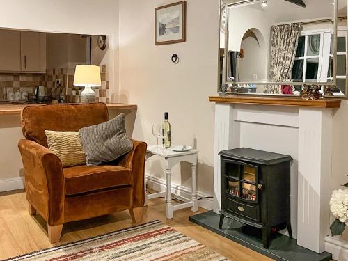 a living room with a chair and a wood stove at The Farriers - 26967 in Windermere