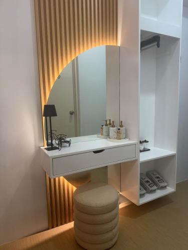 a bathroom with a vanity with a mirror and a stool at CDO Nest in Cagayan de Oro