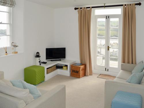 Una sala de estar con un sofá y un televisor. en Charborough House Apt 3, en Salcombe