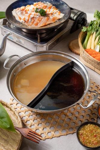 a table with two pans of food on a table at Tongna Cottage Natural Resort in Chiang Mai