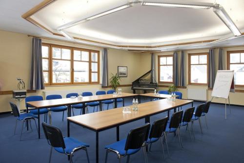 a room with tables and chairs and a piano at Luise Wehrenfennig & Haus EvA in Bad Goisern