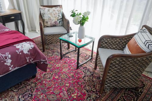 a bedroom with a bed and a table and chairs at Sheilan House in Port Alfred