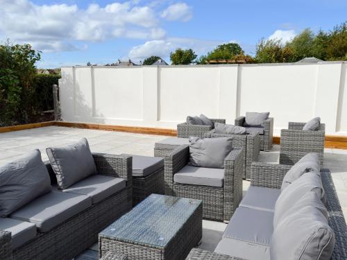 a row of wicker chairs and tables on a patio at Estuary View in Lympstone