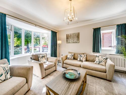 a living room with two couches and a table at North Lodge Cottage in Chester-le-Street