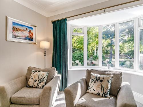 a living room with two chairs and a window at North Lodge Cottage in Chester-le-Street