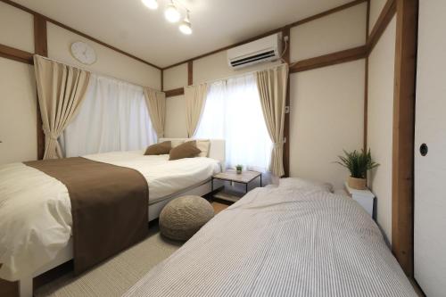 a bedroom with two beds and a window at Quiet 1K Full Room, Serta Queen Bed, Good to Shinjyuku & Ikebukuro, Belluna Dome, 201 in Tokorozawa