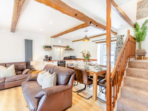 a living room with a table and a couch at Inglenook Cottage in Ingleton