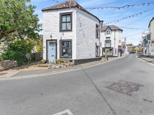 a white building on the side of a street at Inglenook Cottage in Ingleton