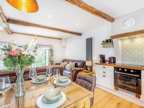 a kitchen and living room with a table and chairs at Inglenook Cottage in Ingleton