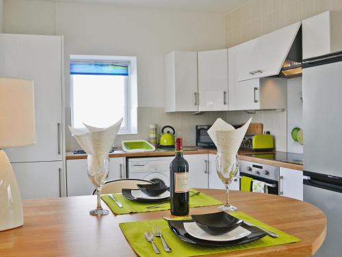 a table with a bottle of wine and two glasses at Llwynbedw - 28464 in Cardigan