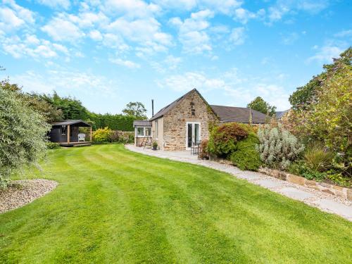 ein Haus mit einer großen Wiese davor in der Unterkunft North End Cottage in Longframlington