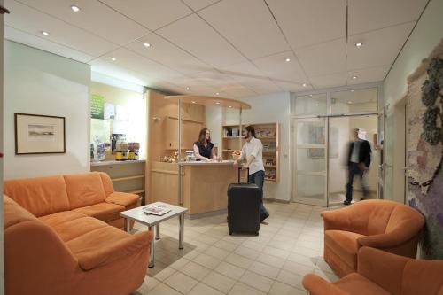 a lobby with a woman with a suitcase in a room at Luise Wehrenfennig & Haus EvA in Bad Goisern