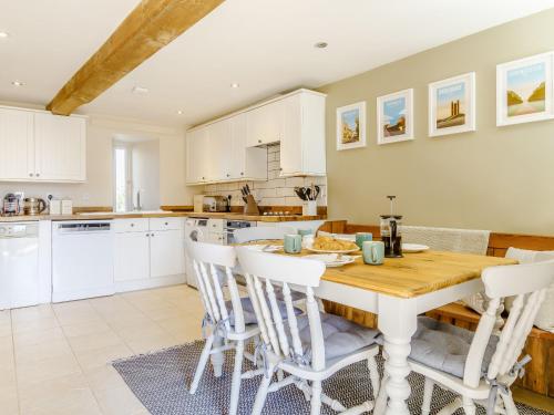 a kitchen and dining room with a wooden table and chairs at Wool Loft in Kemble