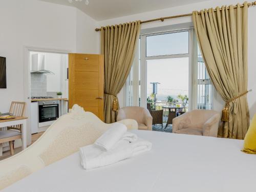 a bedroom with a white bed and a large window at The Downs in Torquay