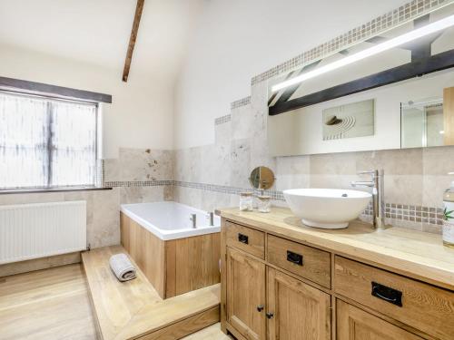a bathroom with a sink and a bath tub and a tubermott at High House Barn - Uk36929 in Foulsham