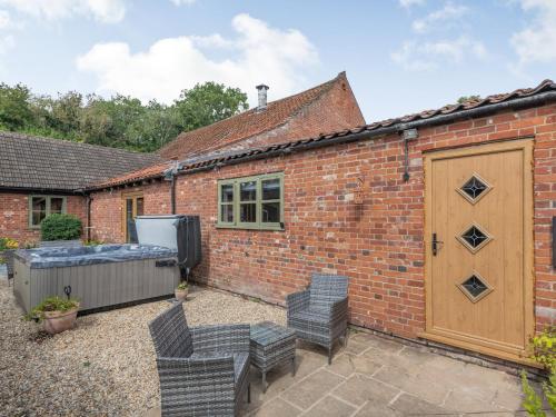 an exterior view of a brick house with patio furniture at High House Barn - Uk36929 in Foulsham