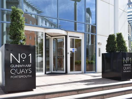 a glass building with a sign in front of it at No1 The Two Bedroom Balcony View in Portsmouth