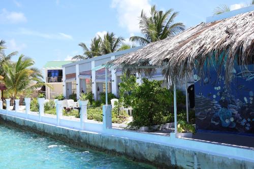 a building on the water next to a resort at Lagoon View in Bodufolhudhoo