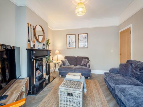 a living room with two couches and a fireplace at Townhouse in Llandudno