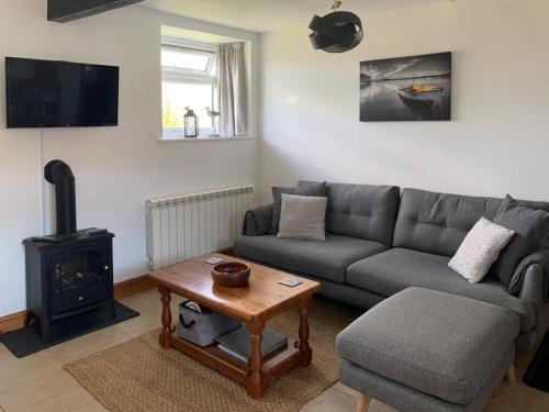 伍尔法迪斯沃西Birdsong Cottage的带沙发和木炉的客厅