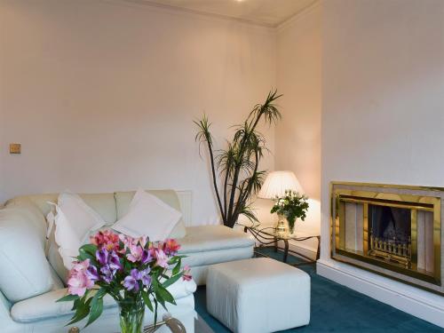 Una sala de estar con un sofá y una chimenea. en Ash Villas, en Southport